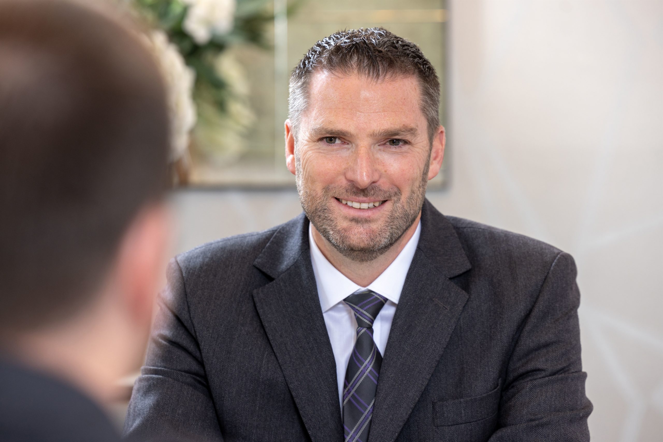 William Purves CEO, TIm Purves, picured in a suit and tie looking just off camera. Recently interviewed regarding funeral industry.